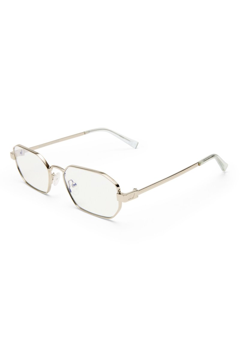 Γυαλιά με μεταλλικό χρυσό πλαίσιο, διαφανείς ορθογώνιους φακούς και ρυθμιζόμενα μαξιλαράκια μύτης, ακουμπώντας σε λευκή επιφάνεια.