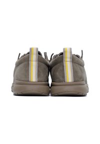 Par de zapatillas de ante gris vistas desde atrás, con tiradores de color amarillo, blanco y gris a rayas en los cuellos del talón.