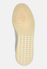 Rubber shoe sole with a textured surface, featuring a circular accent in the center and a light yellow color with geometric patterns.