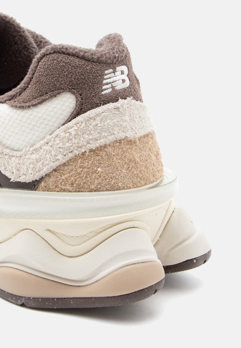Sneaker sportivo chunky con pannelli testurizzati marroni, crema e beige; presenta il logo, una collarina imbottita e un design della suola a strati.