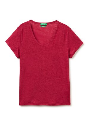 Camiseta de mujer roja de manga corta y cuello redondo, colocada plana con una etiqueta verde de "United Colors of Benetton" en el interior del cuello.