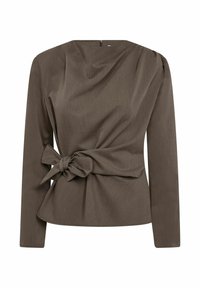 Blusa marrón de manga larga con hombros estructurados y detalle de lazo atado en la cintura, con cierre de cremallera en la espalda.