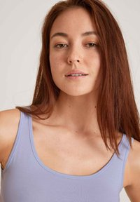 Light purple, sleeveless top with a scoop neckline made from a smooth, stretchy material. Subtle texture and clean edges.