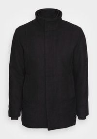 Abrigo de lana negro con cuello alto, bolsillos laterales y mangas largas. Presenta líneas limpias y un diseño minimalista.