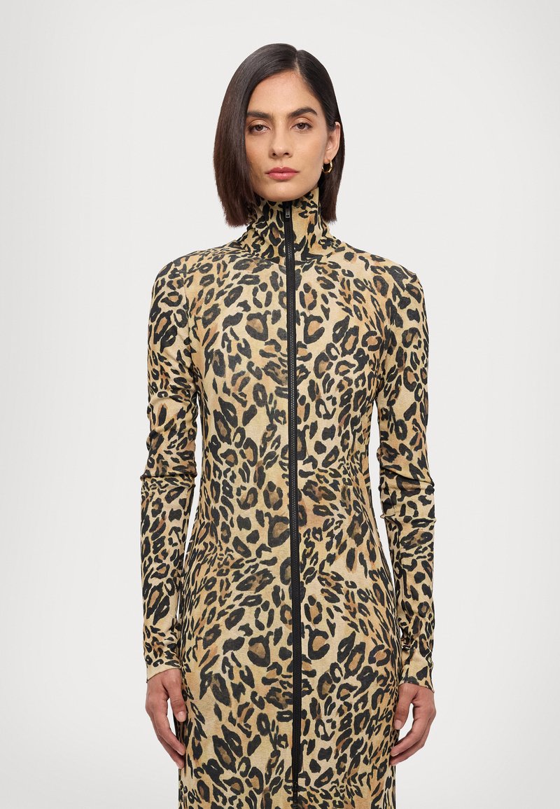 Leopard print dress made of stretch fabric; features a high collar and long sleeves, with a front zipper and a form-fitting silhouette.