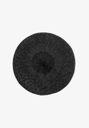 Czarna dziergana beretka z fakturowaną powierzchnią, z rozsianymi białymi i czarnymi koralikami. O okrągłym kształcie z centralnym otworem.