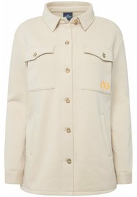 Veste-chemise en mélange de coton beige avec fermeture à boutons sur le devant, deux poches poitrine, un logo brodé en orange et un col classique.