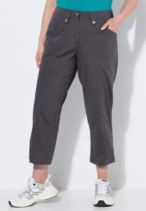 Szare krótkie spodnie wykonane z lekkiego materiału, z przednimi kieszeniami, zapięciem na guzik i kontrastowym przeszyciem. Połączone z białymi trampkami.