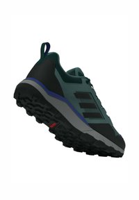Trailrunning-Schuh mit einem dunkelgrünen synthetischen Obermaterial, schwarzer Polsterung und einer strukturierten Gummisohle mit tiefen Stollen für besseren Halt.