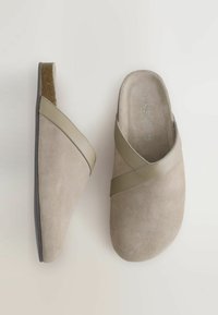 Bēšas nubuka kurpes ar pārvelkamu dizainu gaiši olīvu zaļā krāsā. Apaļa purngala un teksturēta iekšzole, ar zemu papēdi.