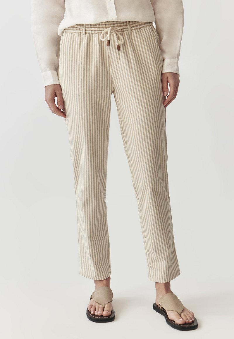 Pantalones a rayas en beige y crema con cintura ajustable con cordón, confeccionados en una tela ligera, con pierna ajustada y textura suave.