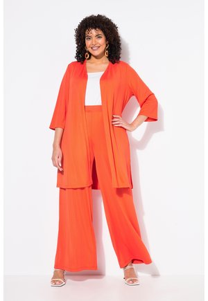 Helles Orange, leichtes zweiteiliges Set, das weite Hosen und eine lange, offene Kimono-Jacke über einem weißen Oberteil umfasst.