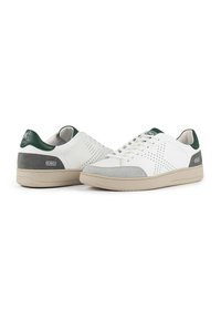 Sneakers bianchi in pelle con accenti verde e grigio, dotati di dettagli perforati e suola in gomma beige. Design con lacci e etichette con marchio.