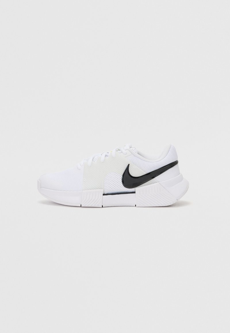 Weißer Sportschuh aus Mesh und synthetischem Material, mit einem schwarzen Nike-Swoosh, Schnürverschluss und strukturiertem Sohlen.