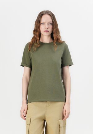 Oliven grønn kortermet t-skjorte laget av myk stoff, med rund hals og avslappet passform. Brukt sammen med beige cargo-bukser.