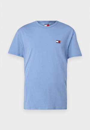 Lichtblauw katoenen T-shirt met korte mouwen, een ronde hals en een klein logo met rode, witte en zwarte accenten op de borst.