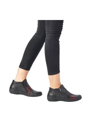 Bottines noires à talons avec des accents rouges, en cuir lisse, fermeture éclair, panneaux texturés et une semelle en caoutchouc courbée. Convient pour une tenue décontractée.