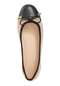 Beige suède ballerina met een zwarte leren neuspunt, zwarte afwerking en een strikaccent bovenop, met een gladde binnenvoering.