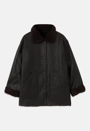 Giubbotto di pelle nera con colletto e polsini in shearling marrone, dotato di chiusure frontali a bottoni e due ampie tasche laterali.