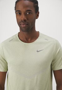 Nike Performance RISE - T-shirt desportiva - olive aura heather/silver