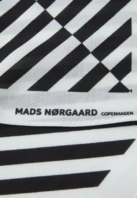Black and white patterned fabric featuring diagonal stripes. The brand name "MADS NØRGAARD COPENHAGEN" is visible along the bottom edge.