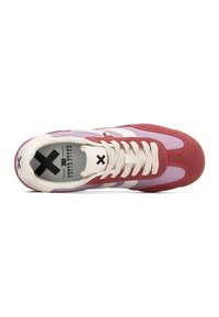 Zapatilla multicolor que presenta una mezcla de burdeos, púrpura clara y blanco. Material de gamuza suave con rayas blancas y detalle de logo negro.