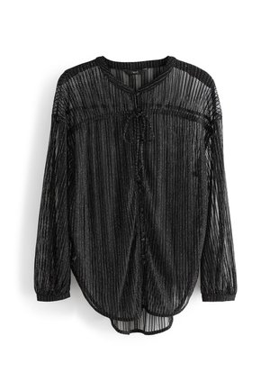 Černá průsvitná halenka s dlouhým rukávem, vertikální pruhy, přední zavazovací detail, kulatý výstřih a elastické manžety, visící na bílém pozadí.