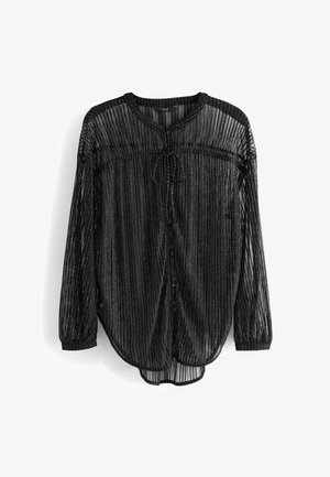 Blouse noire transparente à manches longues avec rayures verticales, détail noué à l'avant, encolure ronde et poignets élastiques, suspendue sur un fond blanc.