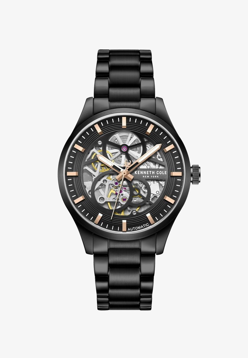 Zwarte automatische horloge met een skeleton wijzerplaat, die ingewikkelde mechanismen toont, benadrukt door gouden en zilveren details, en een zwarte metalen armband.