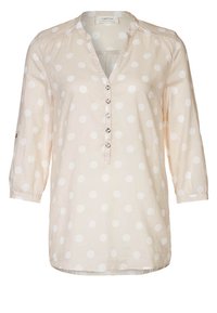 Blusa beige chiaro con pois bianchi, maniche a tre quarti, abbottonatura con bottoni rotondi, tessuto morbido, vestibilità comoda, orlo curvo.
