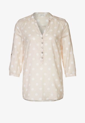 Blouse beige clair à pois blancs, manches trois-quarts, patte de boutonnage avec boutons ronds, tissu doux, coupe décontractée, ourlet arrondi.