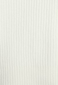 Geribbeld breiwerk in off-white met een zachte textuur. Bevat verticale lijnen en een lichte elasticiteit, geschikt voor verschillende kledingontwerpen.