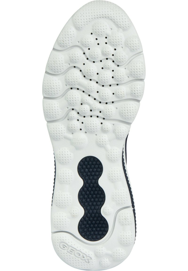 Suela de zapato de goma blanca con patrones texturizados, que presenta indentaciones circulares y ovaladas, además de agujeros de ventilación para transpirabilidad.