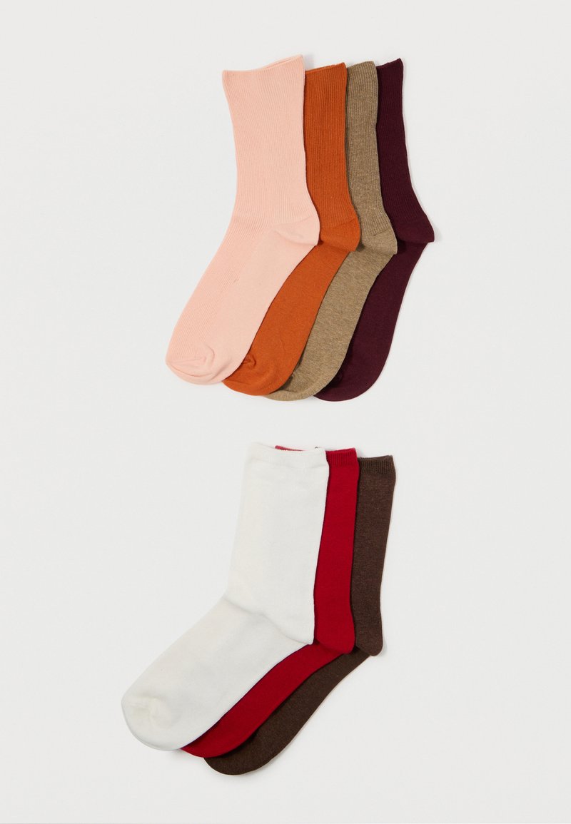 Verpakking van zes paar sokken in verschillende effen kleuren: roze, oranje, beige, bruin, burgundy, wit en rood. Ribbelstructuur overal.