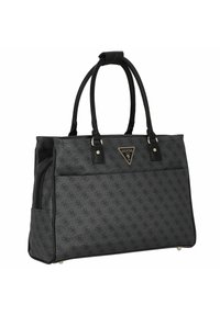 Borsa tote nera Guess con stampa logo a motivo, manici doppi, tasca frontale e emblema del brand in metallo triangolare su sfondo bianco.