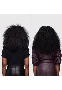 Twee personen met krullend zwart haar: de ene in een zwart hemd met korte mouwen, de andere in een bordeauxleren jack. Beiden van achteren bekeken.