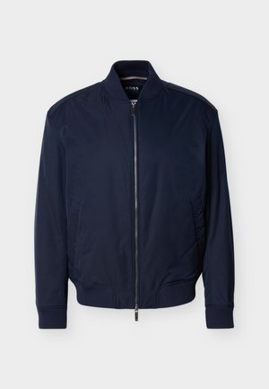 Μπλε ναυτικό bomber μπουφάν με κλείσιμο με φερμουάρ, ριμπ γιακά, μανσέτες και τελείωμα. Λείο υλικό και πλαϊνές τσέπες. Μινιμαλιστικός σχεδιασμός χωρίς μοτίβα.