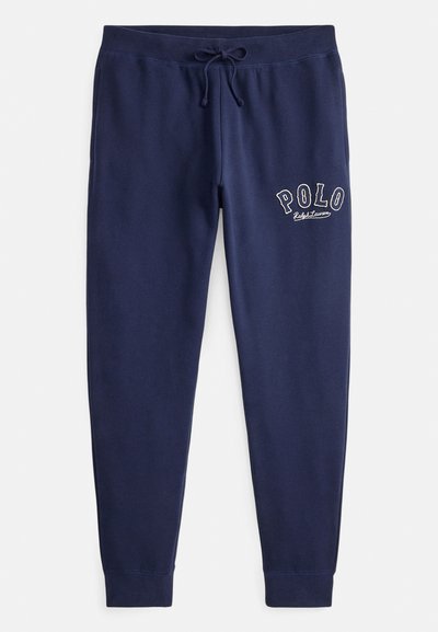 Granatowe bawełniane spodnie dresowe z elastycznym pasem i regulowanym sznurkiem. Na lewej udzie haftowane białe logo "POLO".