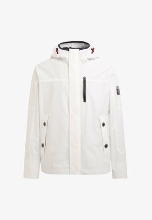 Chaqueta blanca impermeable con capucha, cremalleras y bolsillos abotonados, con acentos negros y un parche de logo en la manga.