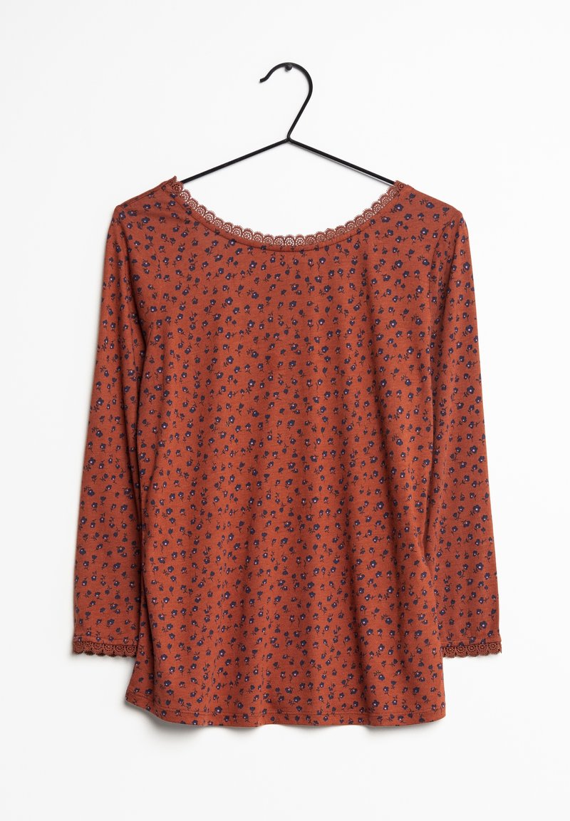 Långärmad rostfärgad topp med blått blommönster, vågig halsringning och ärmslut. Tillverkad av mjukt tyg med en avslappnad passform och rundad nederkant.
