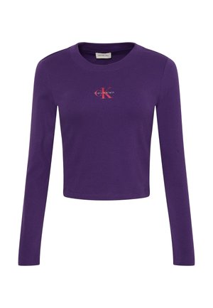 Lila Crop-Top mit langen Ärmeln aus Baumwolle, verfügt über ein kleines rotes Logo auf der Brust, einen runden Ausschnitt und eine gerippte Textur.