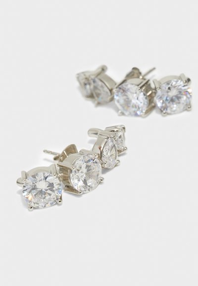 Σειρά από τέσσερα ζευγάρια σκουλαρίκια με ασημί απόχρωση, διακοσμημένα με καθαρούς, στρογγυλούς κρύσταλλους σε διάφορα μεγέθη, όλα με ασφαλές κλείσιμο καρφίτσας.