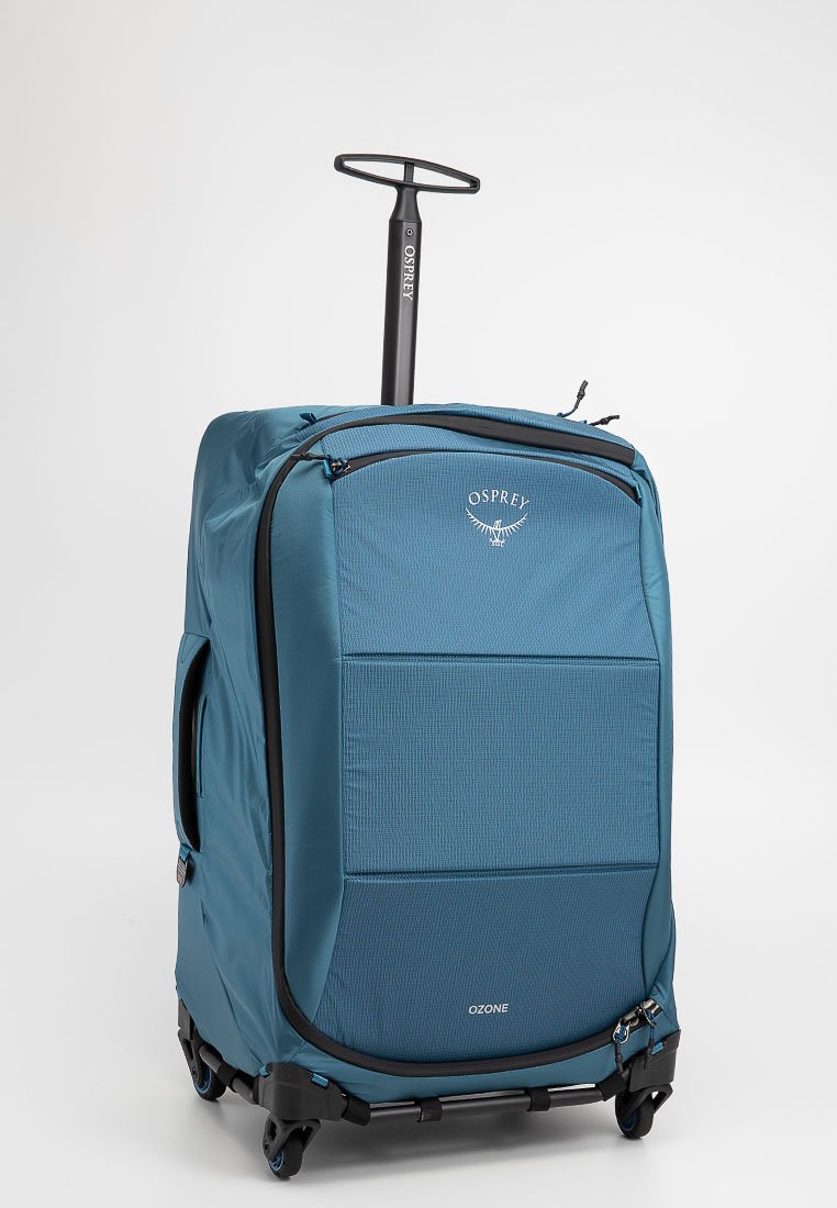 Maleta Osprey Ozone en tela azul con un patrón texturizado, ruedas negras y un mango retráctil. Compartimento con cremallera en la parte superior.