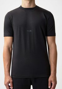 Svart T-shirt med kort ärm, tillverkad av mjukt tyg, med rundad halsringning och en liten broderad "BALR."-logotyp på bröstet.