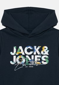 Marineblaue Hoodie mit einem frontalen Grafik-Textdesign im mehrfarbigen Farbverlauf-Stil. Ausgestattet mit einer Kordelzugkapuze und einem weichen Stoffgefühl.