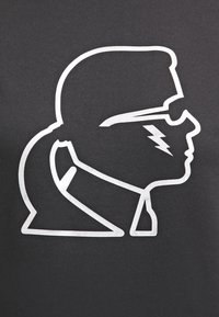 Černé tričko s stříbrným grafickým designem bočního profilu s brýlemi a akcentem blesku, vytvořené s hladkým, metalickým povrchem.