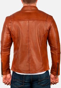 Bordeaux leren jas met een getailleerd ontwerp, staande kraag en ritsdetails op de manchet. Glad textuur en zorgvuldig gestikte naden.