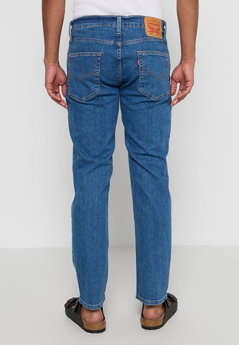 Jeans in denim blu con taglio dritto, dotati di una patch sulla vita e doppie tasche posteriori con dettagli di cucitura.