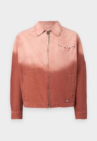 Denim jacket in a gradient of peach to rust. Features a front zip, pointed collar, and a chest pocket with a triangular flap.