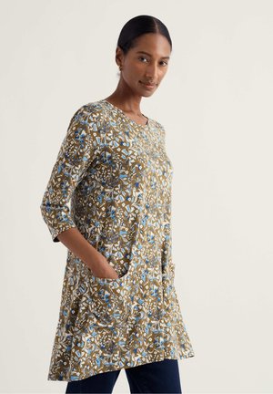 Brauner floraler Tunikatop mit rundem Ausschnitt, dreiviertel Ärmeln und seitlichen Taschen. Das Muster zeigt blaue und weiße Blumen auf einem strukturierten Stoff.